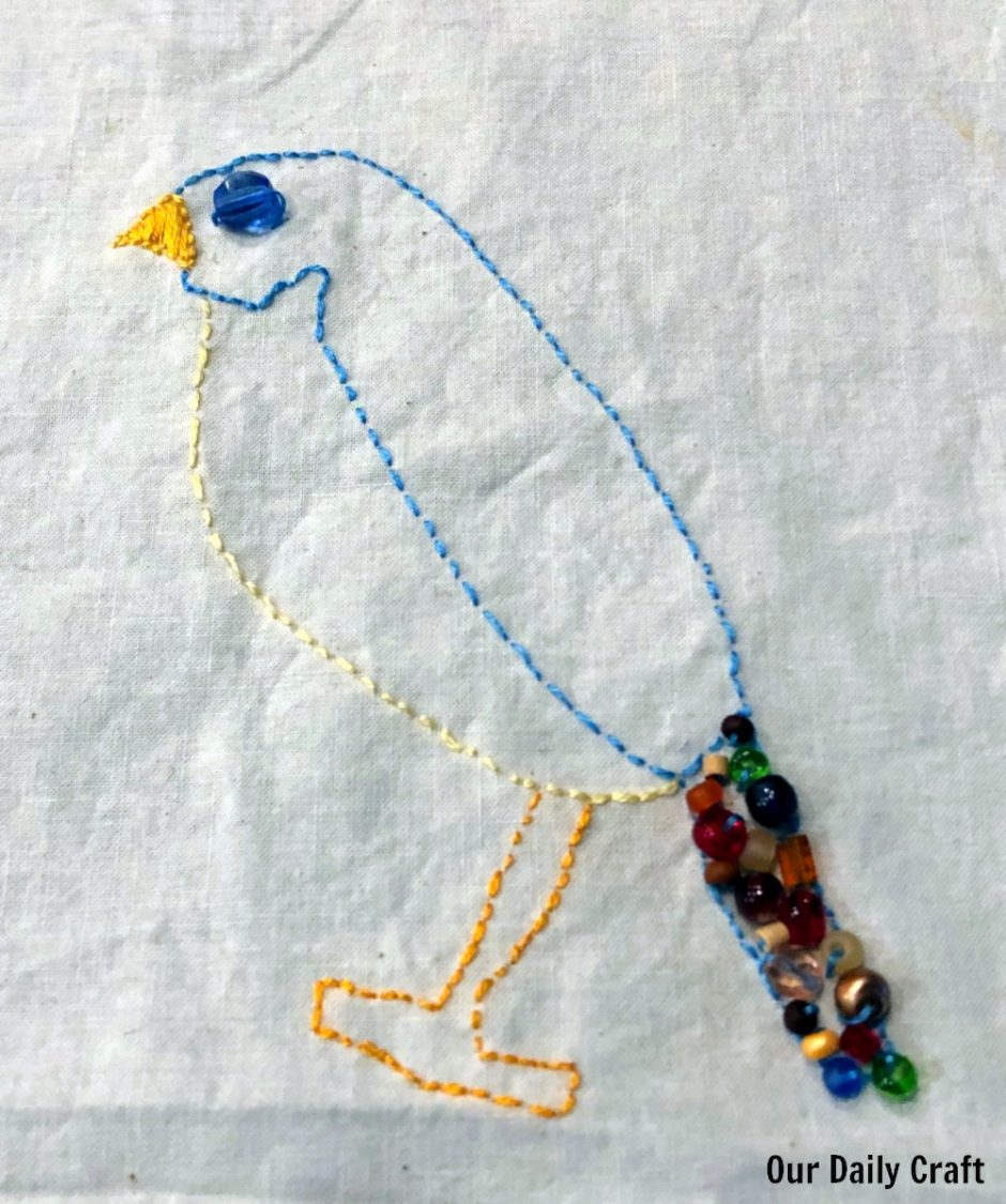 embroidered bird with beaded tail